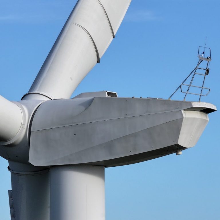 Close-up of a wind turbine's rotor hub against a blue sky.